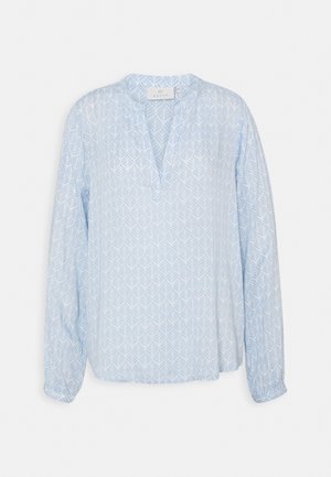 Blusa a maniche lunghe di colore azzurro chiaro con scollatura a V, caratterizzata da un sottile motivo geometrico a foglie e polsini elasticizzati. Tessuto morbido e leggero.