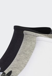 Fire par sokker i sort, grå og hvid. Stoffet er glat med ribbede manchetter. Det grå par har en subtil stribet tekstur.