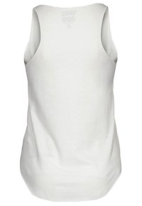 Valkoinen hihaton toppi, joka on valmistettu sileästä kankaasta. Siinä on pyöreä pääntie, hieman kaareva helma ja takana logo.