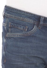 Jeans de mezclilla en azul oscuro, con cinco bolsillos, diseño de pierna recta y costuras en naranja contrastantes. Textura suave, ajuste clásico.