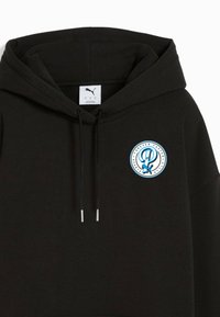 Felpa nera con una texture morbida, caratterizzata da un logo circolare blu e bianco sul petto e stringhe con punte metalliche.
