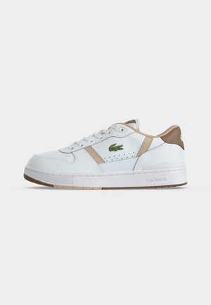 Baskets basses blanches Lacoste avec des accents beige, logo crocodile vert et semelle plate en caoutchouc, vues de profil sur fond blanc.
