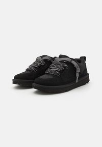 Baskets noires avec un mélange de matériaux en daim et en maille, des lacets texturés et une semelle extérieure robuste pour l'adhérence et la durabilité.