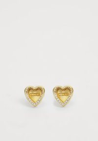 Zlatne naušnice u obliku srca s teksturiranim završetkom, koje sadrže "GUESS" logo i okružene su redom prozirnih rhinestones.