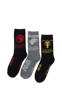 Drei Paar Baumwollsocken in Schwarz, Grau und Schwarz, mit Hauslogos aus "Game of Thrones" in rot, weiß und gelb.