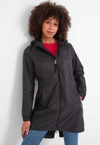 Black waterproof jacket with a zip front, adjustable hood, elastic cuffs, and side pockets, paired with a red shirt and blue jeans.