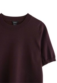Bordeaux gebreid t-shirt met korte mouwen en een geribbelde ronde hals, met een soepele textuur, gekenmerkt door minimale stiksels en zonder zichtbare patronen.