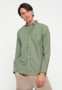 Groen gestreepte button-up shirt met een kraag, voorzien van witte knopen en een klein logo op de borst. Lange mouwen met detail aan de manchetten.