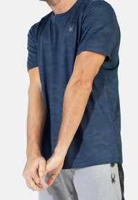 Námořnická modrá tričko s krátkým rukávem s jemným vzorem maskáče a šedým logem pavouka na levé hrudi; vyrobeno z prodyšného materiálu.