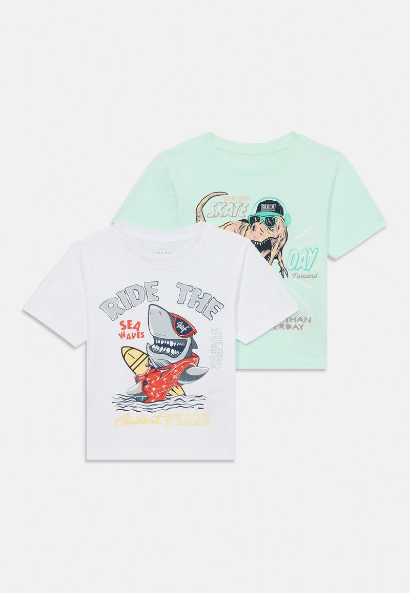 Conjunto de duas t-shirts para crianças: uma branca com um gráfico de tubarão em vermelho e azul, e uma verde-menta com um dinossauro de óculos de sol.