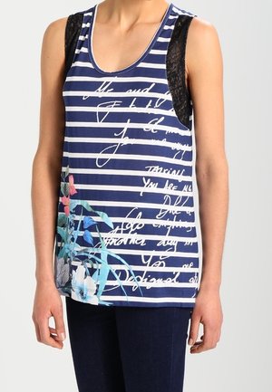 Haut sans manches rayé bleu et blanc avec des panneaux d'épaule en dentelle noire, texte cursif blanc et imprimé floral coloré près de l'ourlet.