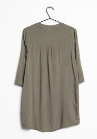 Olive green dress with a round neckline, three-quarter sleeves, pleated back design, and smooth texture. Hangs from a black hook.