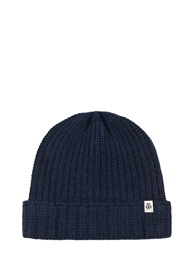 Navy blue knitted beanie with a folded brim and a small white tag featuring a black emblem on the cuff.