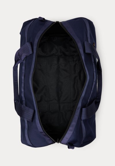 Σκούρο μπλε τσάντα duffel με μαύρη εσωτερική επένδυση, πλήρως ανοιχτή, εμφανίζοντας μια μεγάλη κύρια θήκη και δύο λαβές μεταφοράς.