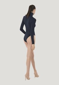 Marinblå långärmad bodysuit med hög krage, med en figurnära design och höga skärningar vid benen, tillsammans med nudefärgade plattformsskor.