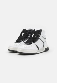 Hvite høye sneakers med svarte detaljer, i lærmateriale, snøring, perforert tå og merkevare på siden.