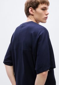 Τιρκουάζ μπλε υπερμεγέθης μπλούζα με κοντά μανίκια, απαλής υφής, με λεπτομέρεια ραφής στην πλάτη και άνετη εφαρμογή.