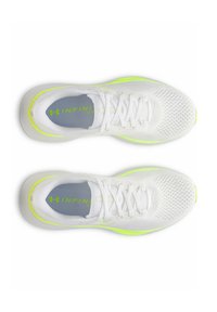 Zapatillas deportivas blancas con parte superior de malla, plantilla gris y detalles en amarillo brillante en la suela. Se pueden ver los cordones y las perforaciones para ventilación.
