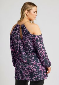Blusa a maniche lunghe di un blu navy scuro con un motivo astratto rosa. Presenta un design con spalle scoperte e una schiena a chiave con dettaglio di catena dorata.