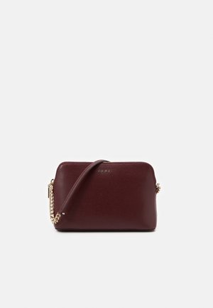 Donkerbruine leren crossbodytas met gouden kettingriem en klein DKNY-logo aan de voorkant.