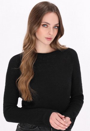 Pulover negru tricotat cu un finisaj texturat, guler rotund și mâneci lungi. Croiala este lejeră, iar materialul pare confortabil.
