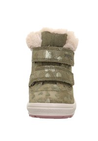 Zelené semišové vysoké tenisky s vzory srdcí, huňatým béžovým lemem a dvěma suchými zipy. Bílé gumové podrážky s růžovými akcenty.