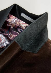 Brown velvet jacket with a black felt collar and a colorful paisley-patterned lining visible at the neck opening.