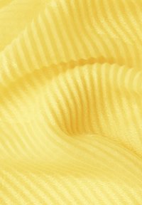 Tissu jaune doux avec une fine texture côtelée horizontale, délicatement plié créant des jeux de lumière et d'ombre.