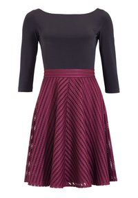 Vestido burdeos con un corsé negro ajustado y una falda acampanada que presenta recortes en chevrón, tela texturizada y un detalle de cintura trenzada.