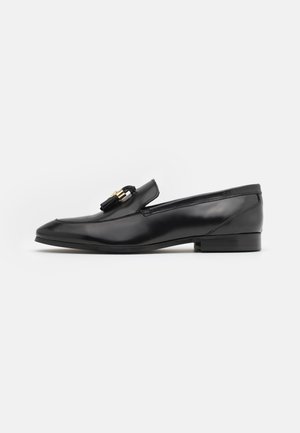 Mocassins en cuir noir au design épuré, à bout arrondi et avec des détails en métal doré. Talon bas et finition lisse, adaptés aux occasions formelles.