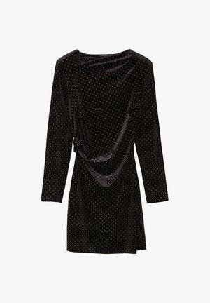 Abito di velluto nero con maniche lunghe, motivo a pois dorati e un dettaglio drappeggiato sul davanti. Texture liscia e silhouette rilassata.