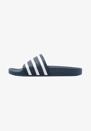 Sandale slide Adidas bleu marine avec trois bandes blanches sur la bride et semelle intérieure texturée, vue latérale sur fond blanc.