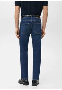 Vaqueros de mezclilla azul oscuro con corte recto, cinco bolsillos y un cinturón negro. Presentan costuras dobles y una textura suave.