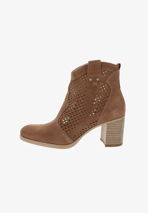 Stivaletto alla caviglia in suede marrone con pannelli laterali perforati, tacco a blocco impilato e linguetta di tiratura sulla parte superiore.
