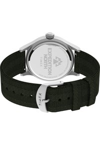 Reloj Timex Expedition North con caja de acero inoxidable. Presenta una correa de tela en color caqui, herrajes plateados y una esfera negra y redonda.
