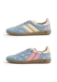 Deux baskets en daim bleu avec semelles en gomme, motifs floraux et rayures contrastées crème et rose, vues de profil sur fond blanc.