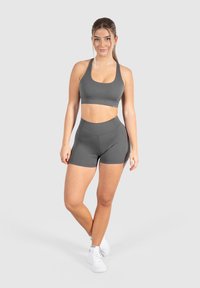 Grijze sport beha en hoge taille short set in een gladde, elastische stof. Bevat een minimalistisch ontwerp met een logo-accent.
