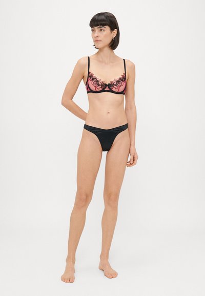 Conjunto de lencería negro y rosa que incluye un sujetador de encaje bordado con tirantes ajustables y unas braguitas negras a juego.