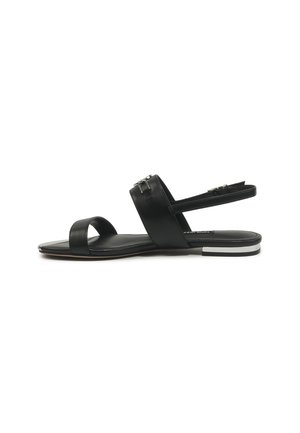 Black flat sandal with two straps, silver buckle accents, and a low heel with white and silver detailing, displayed on a white background.