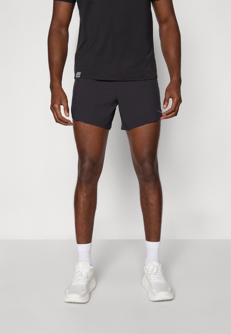 Black athletic shorts in a lightweight fabric, featuring a fitted design. Paired with a black t-shirt and white athletic shoes.