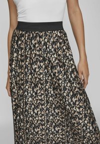 Gonna maxi con sfondo nero e un motivo astratto beige e marrone, vita elasticizzata e tessuto leggero e fluido.