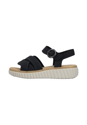 Sandale noire à bout ouvert avec larges brides croisées, bride de cheville avec boucle argentée, semelle intérieure en liège coussinée et semelle blanche épaisse rainurée.