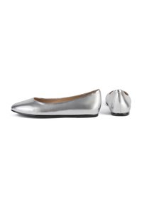 Paire de ballerines argentées métalliques avec bouts arrondis et semelles plates noires, vues de côté et de dos sur fond blanc.