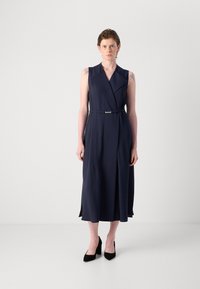 Vestido sin mangas de color marino con un diseño envolvente, cintura ajustada y detalle de cinturón. Presenta rayas verticales y una silueta en A fluida.