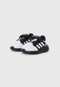 Schwarz-weiße Kinderfreizeitschuhe mit einem Mesh-Obermaterial, gepolstertem Kragen, Klettverschluss und Gummisohle. Mit drei weißen Streifen an der Seite.
