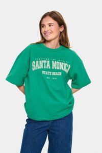 Zelené nadměrné tričko vyrobené z bavlny, se bílým textem "Santa Monica State Beach Est. 1909" v retro písmu. Krátké rukávy.