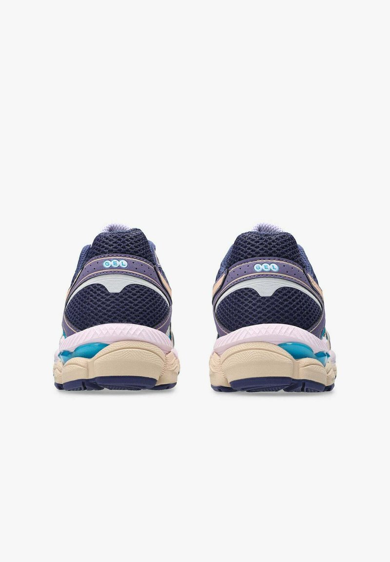 Un paio di scarpe da corsa blu navy e beige con tomaia in rete e ammortizzazione in gel, viste da dietro su uno sfondo bianco.