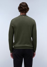 Maglione a maglia verde oliva con polsini e orlo a coste. Presenta un piccolo etichetta accentuata sul retro del collo. Design classico con collo a giro.