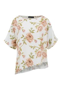 Blouse blanche à manches courtes avec motif floral rose et vert et ourlet asymétrique sur un fond uni.
