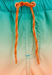 Bermuda de bain avec un design dégradé allant de turquoise à pêche, comportant un cordon de serrage tressé orange et des œillets assortis orange.